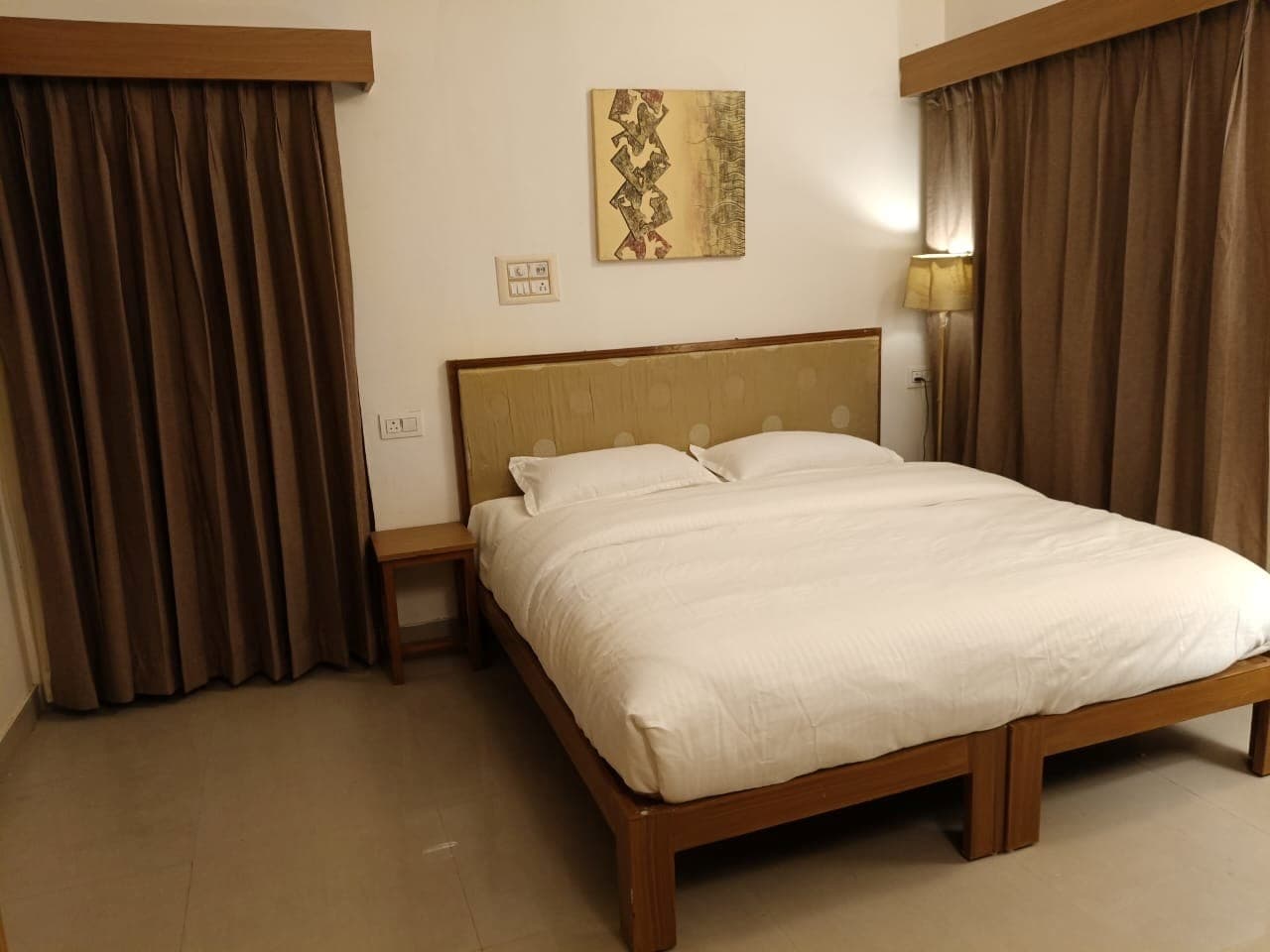 Hawa Mahal at Shivbagh, its bed dressed beneath a golden tufted headboard