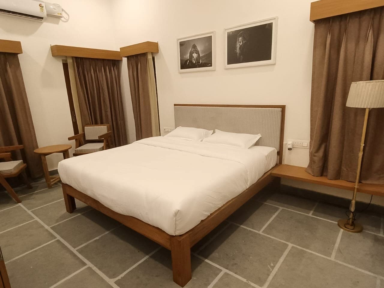 Naya Kamra at Shivbagh, its bed set beneath framed monochrome photographs