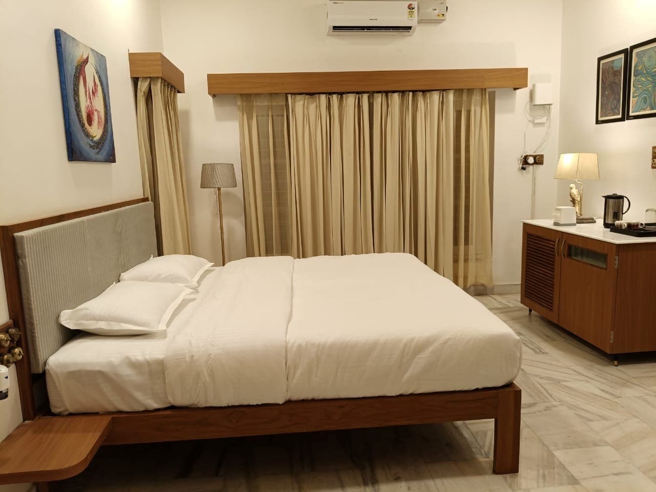 Rang Mahal at Shivbagh, its bed set beneath a colourful abstract painting